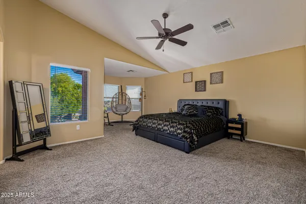 a spacious bedroom with a bed and a painting on the wall