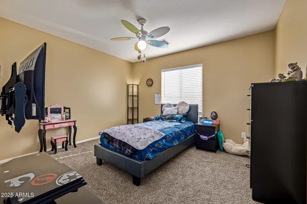 a spacious bedroom with a bed and a chandelier