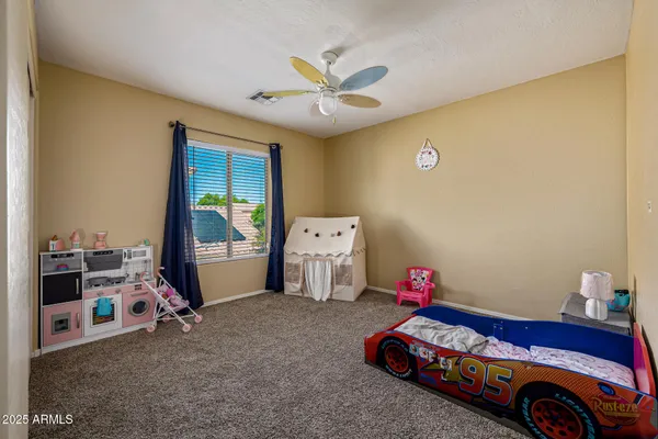 a room with a baby bed and a window
