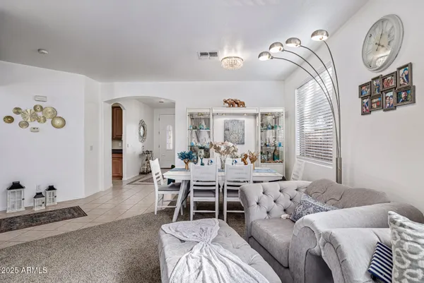 a living room with furniture a clock and a chandelier