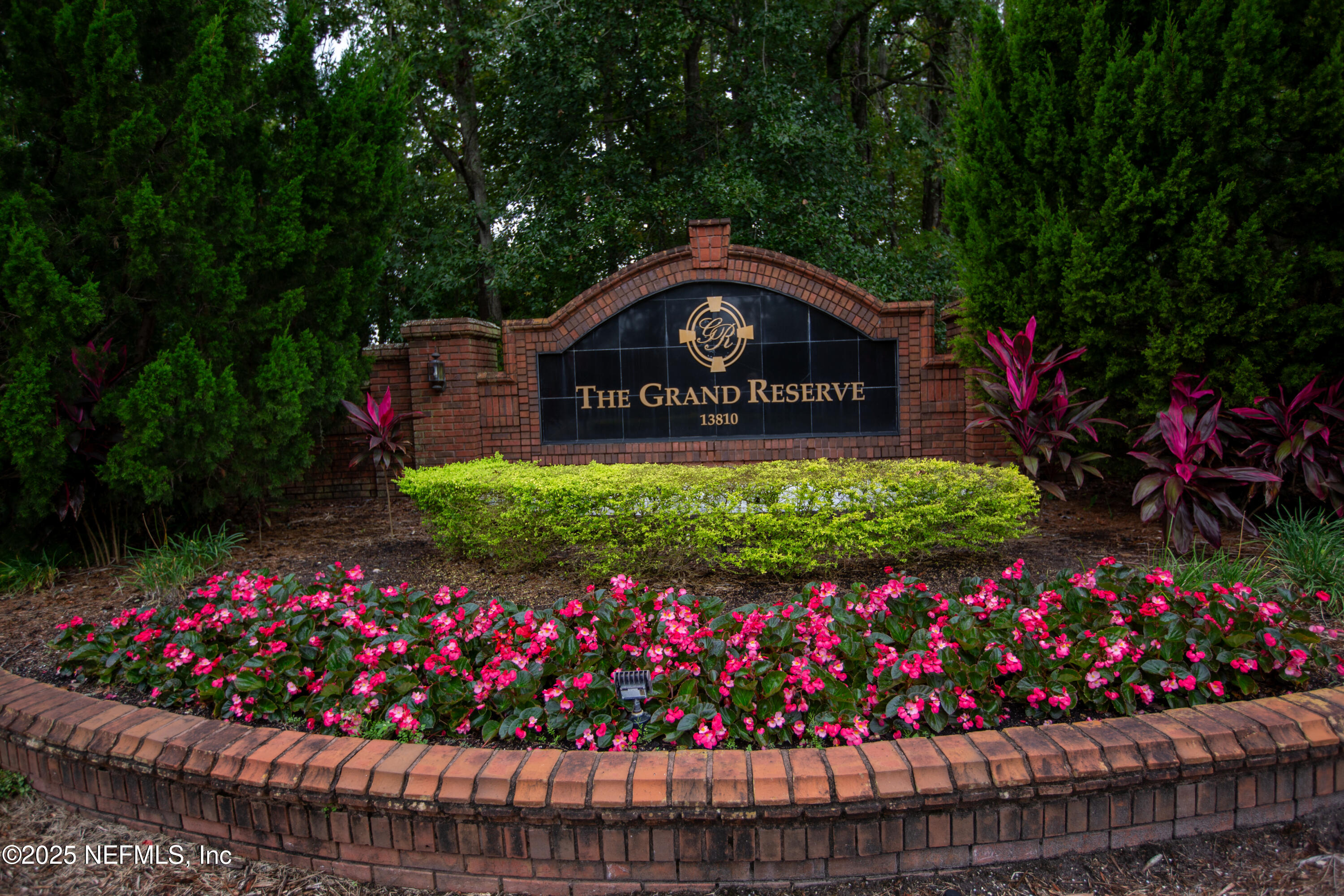 a view of sign board with flowers in the background