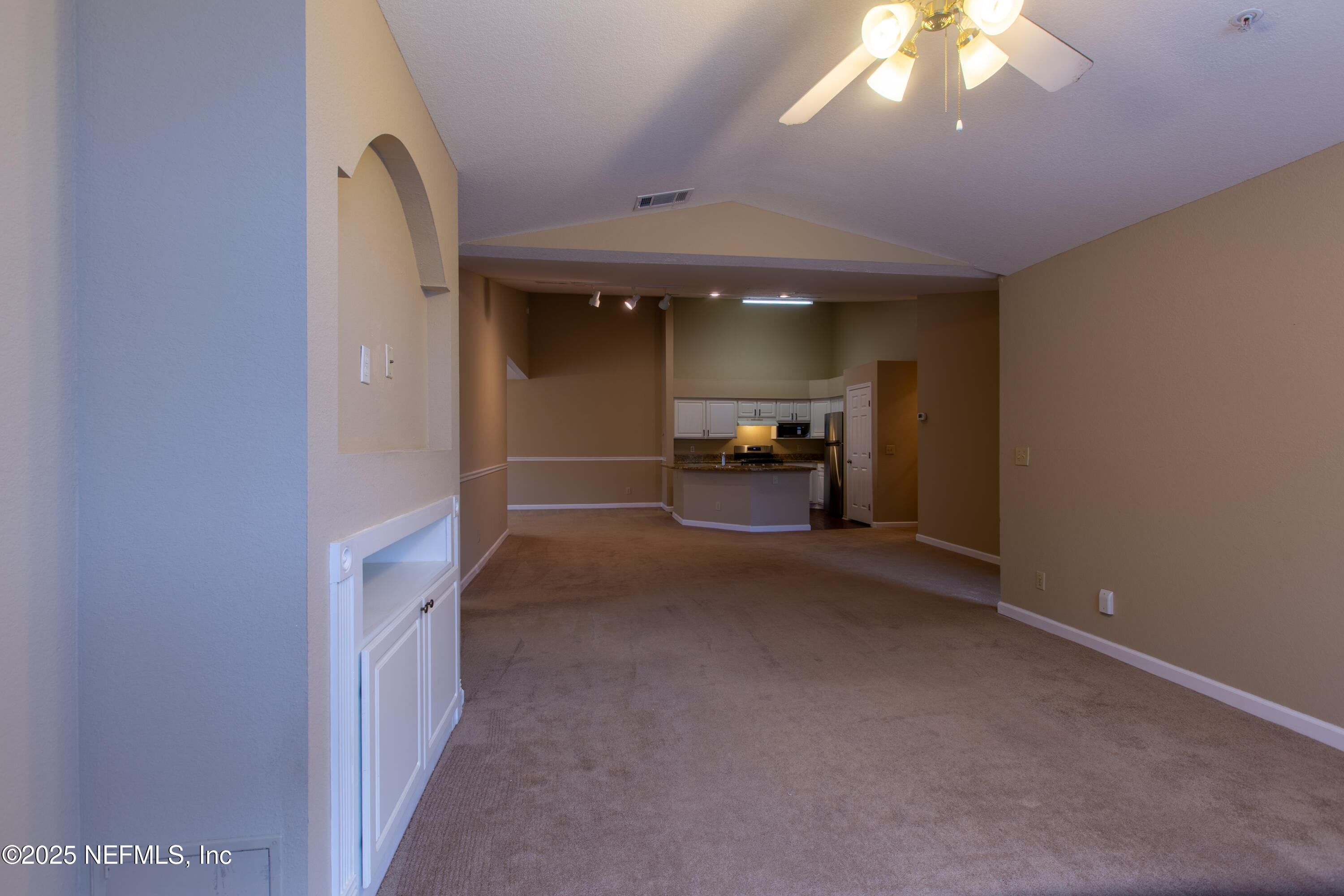 13810 Sutton Park Drive North, Unit 1120 Jacksonville, FL 32224 - Photo 12 of 24 an empty room with chandelier fan and windows