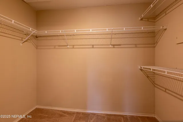 an empty room with windows and chandelier fan