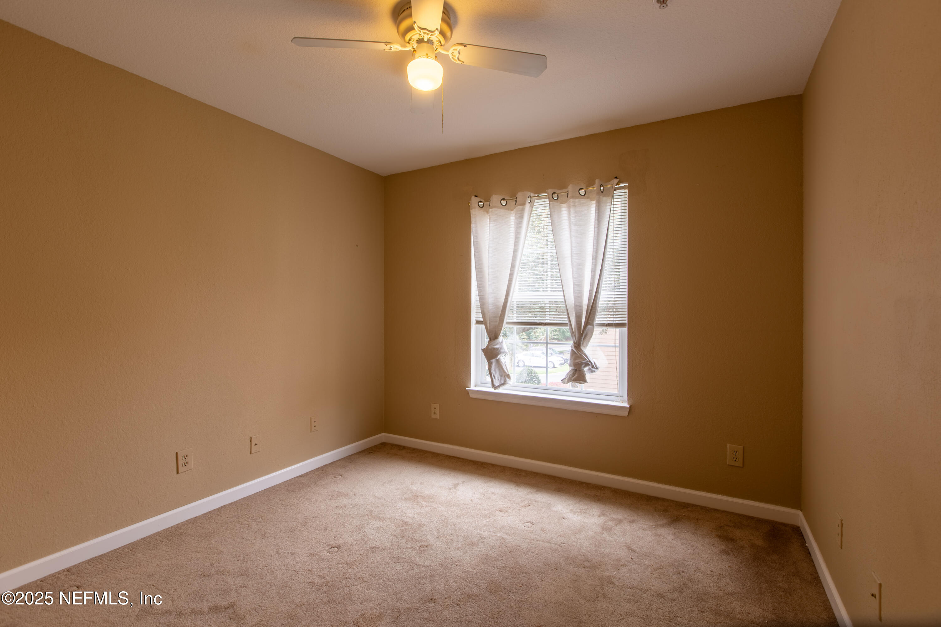 13810 Sutton Park Drive North, Unit 1120 Jacksonville, FL 32224 - Photo 19 of 24 an empty room with windows and chandelier fan