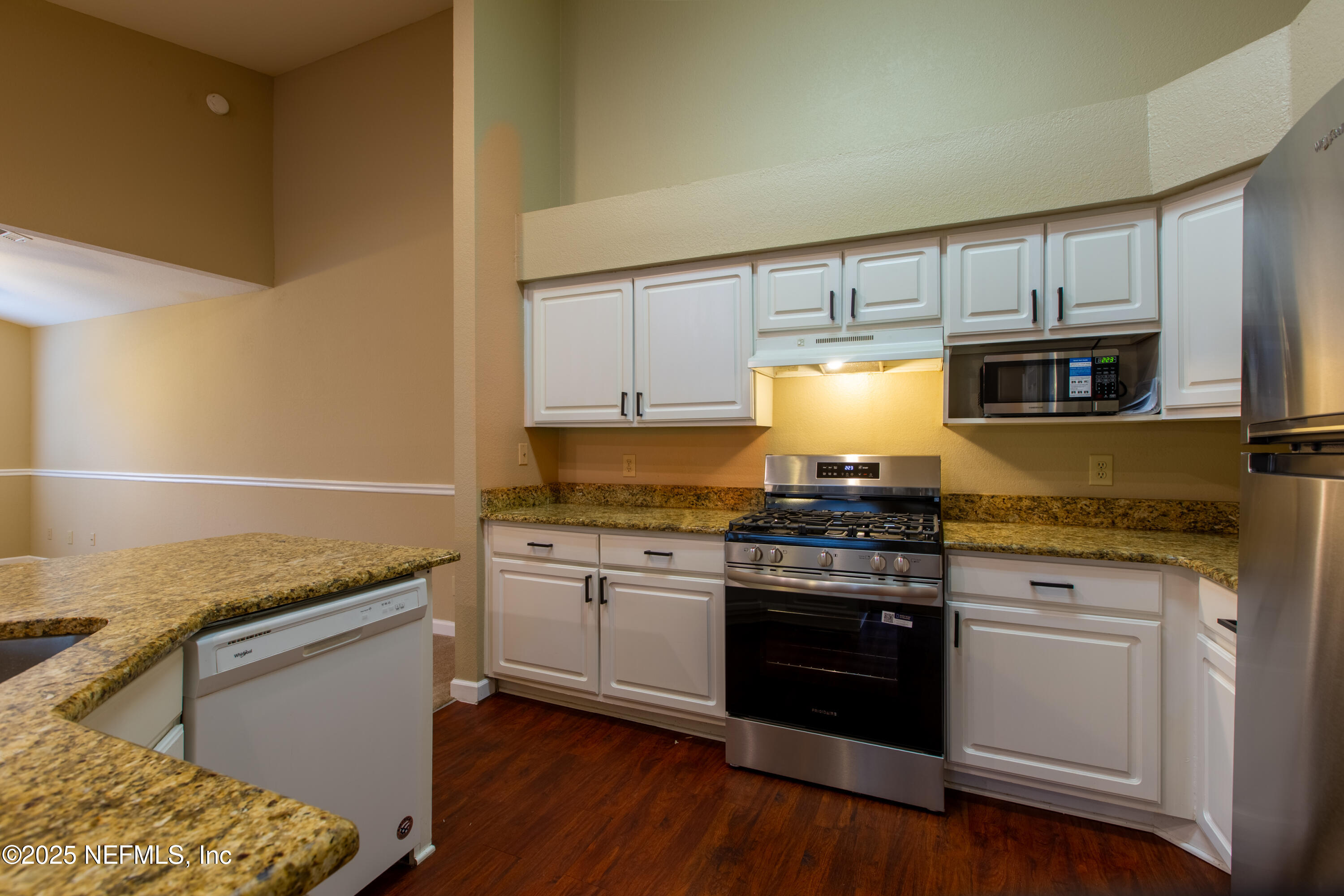 13810 Sutton Park Drive North, Unit 1120 Jacksonville, FL 32224 - Photo 3 of 24 a kitchen with granite countertop wooden cabinets and a stove