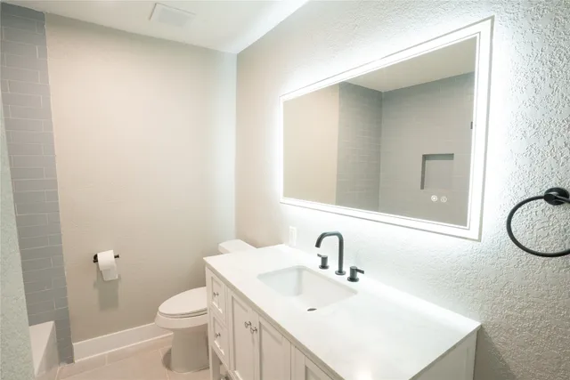 a bathroom with a sink toilet and mirror