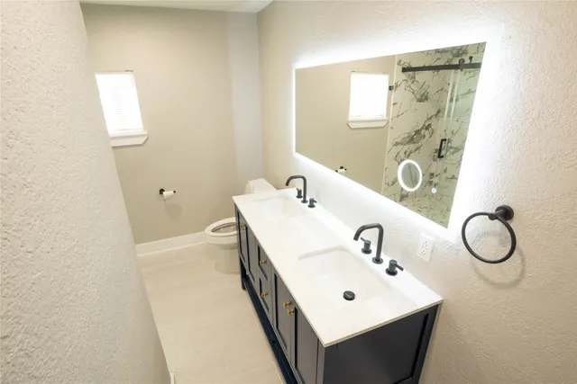 a bathroom with a sink mirror and toilet