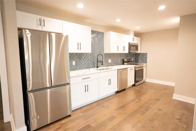 a kitchen with stainless steel appliances a refrigerator sink and cabinets