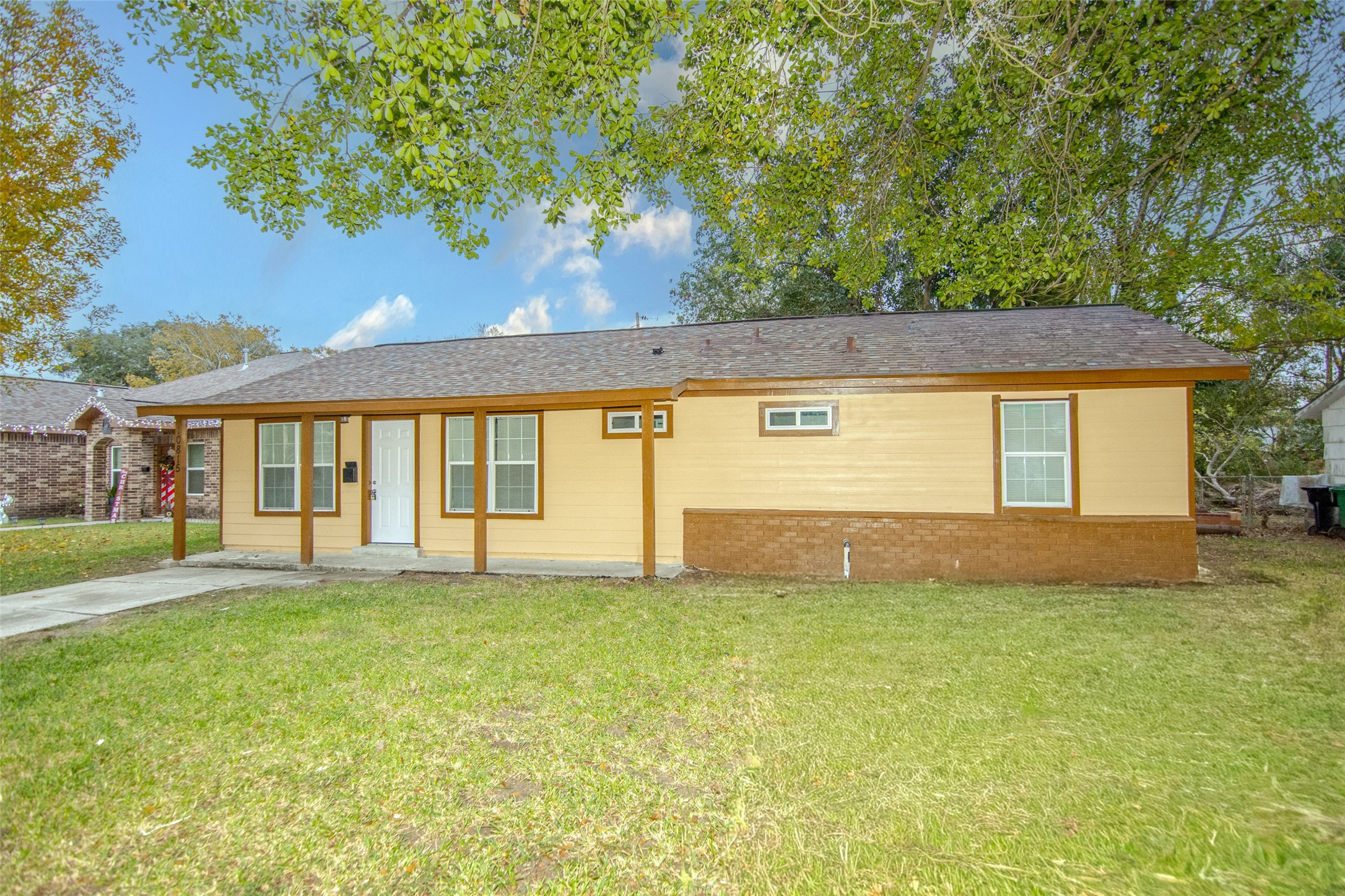 a view of a house with a yard and a large tree