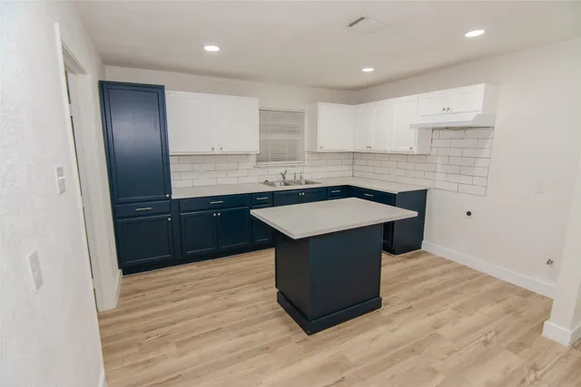 a kitchen with a sink cabinets and wooden floor