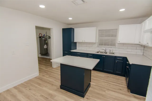 a kitchen with kitchen island stainless steel appliances a sink stove and refrigerator