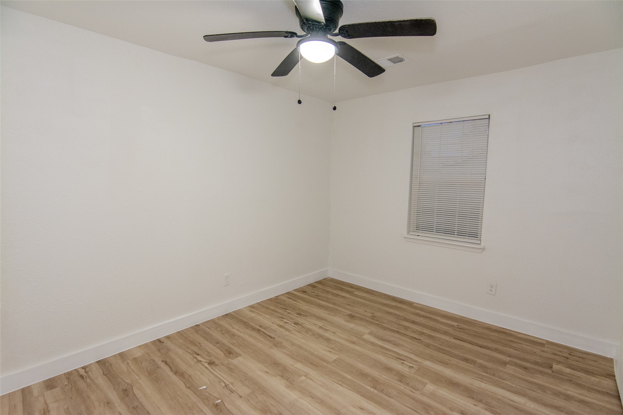 10815 Ritow Street Houston, TX 77089 - Photo 9 of 12 an empty room with a window and a fan