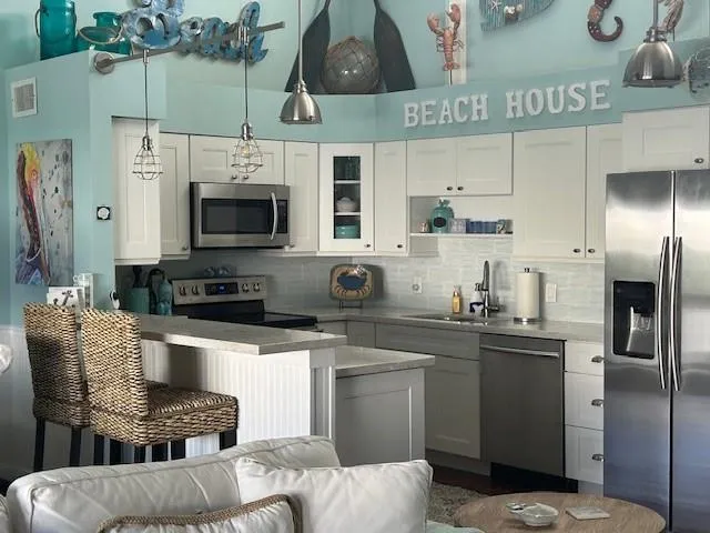 a kitchen with stainless steel appliances a stove a sink and a refrigerator