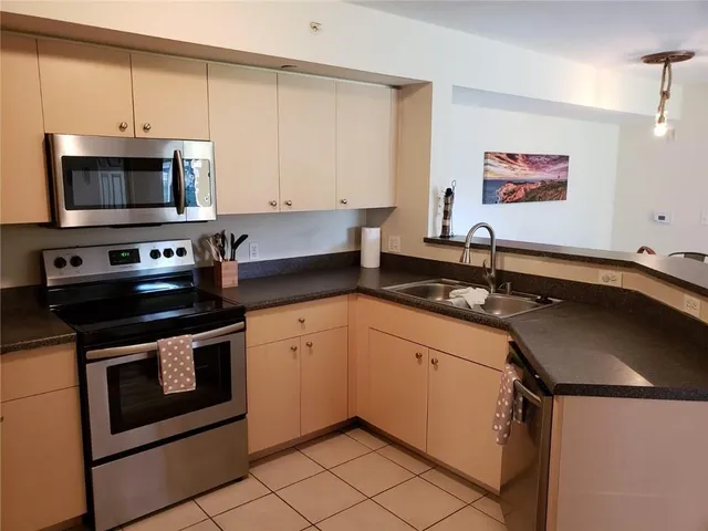 a kitchen with stainless steel appliances granite countertop a sink stove and microwave