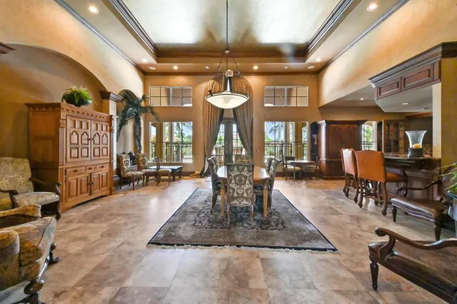 a living room with furniture a chandelier and a dining table
