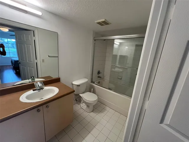 a bathroom with a sink a toilet a mirror and shower