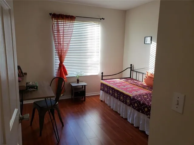 a bedroom with a bed and wooden floor