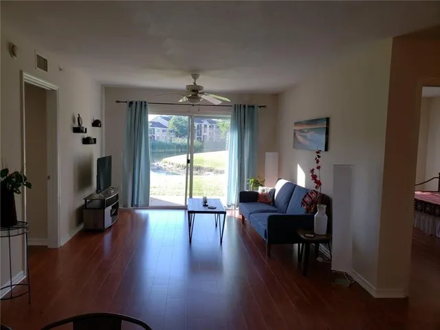 a living room with furniture wooden floor and a flat screen tv