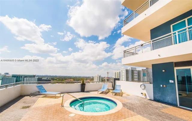 a swimming pool with outdoor seating and barbeque area
