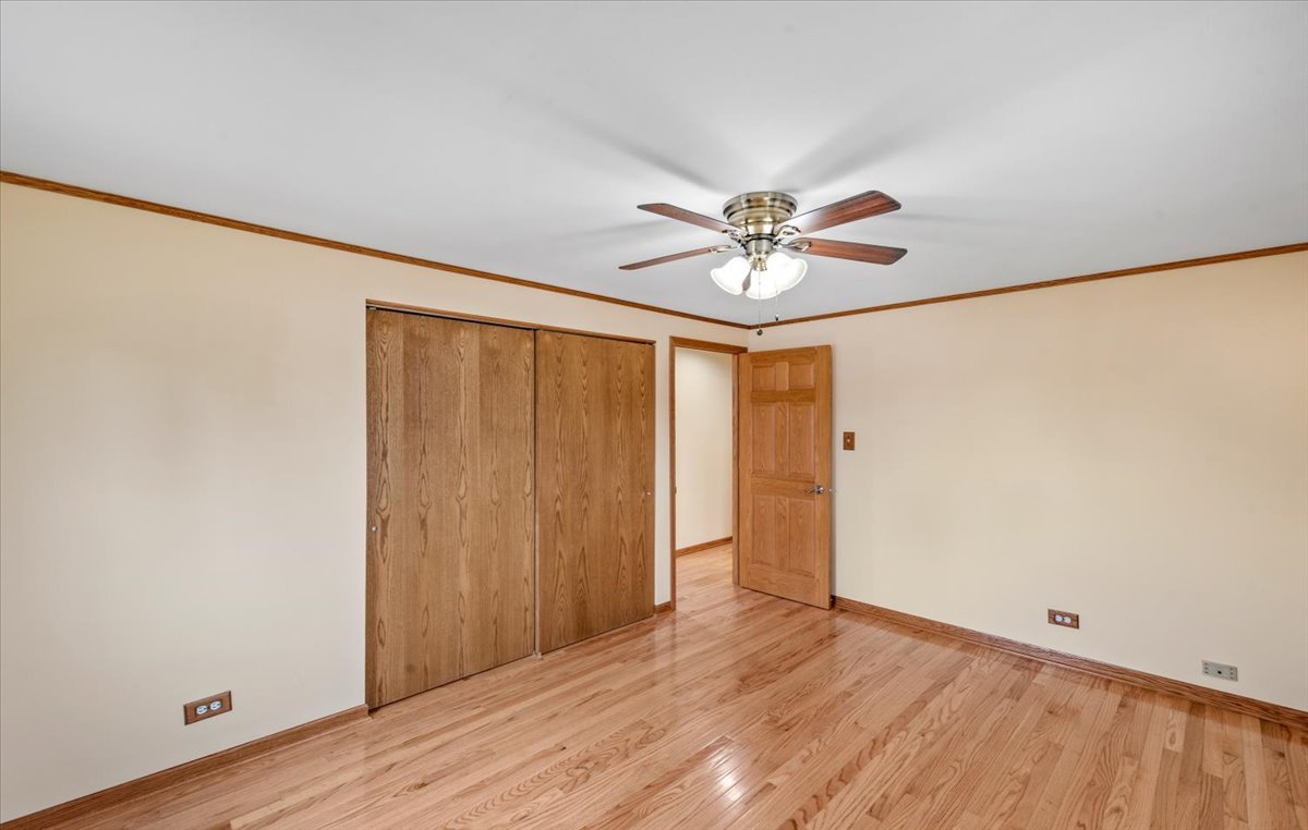 313 Springinsguth Road Schaumburg, IL 60193 - Photo 12 of 39 an empty room with wooden floor and ceiling fan