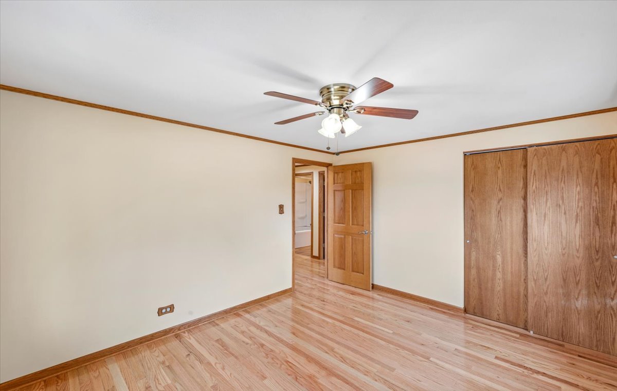 313 Springinsguth Road Schaumburg, IL 60193 - Photo 16 of 39 an empty room with wooden floor and a ceiling fan