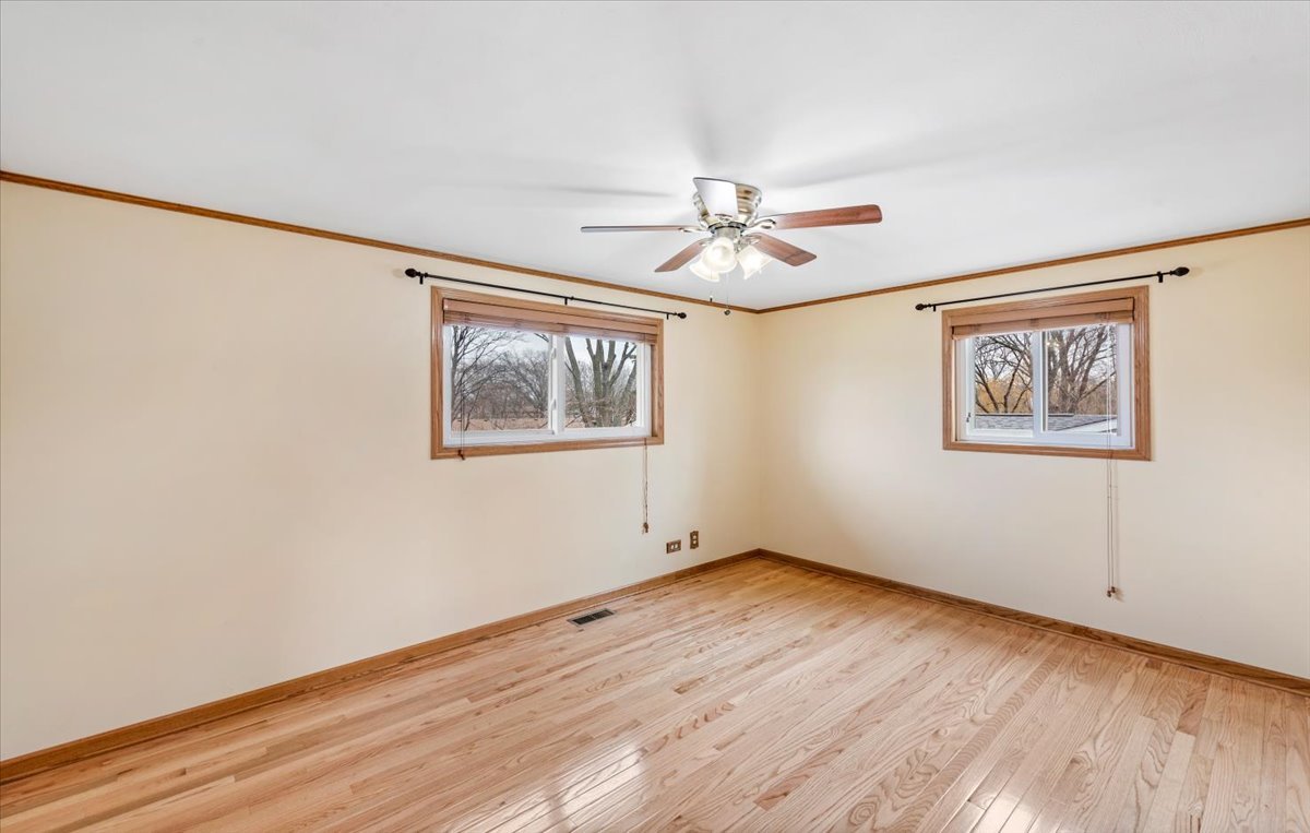 313 Springinsguth Road Schaumburg, IL 60193 - Photo 17 of 39 a view of empty room with wooden floor and fan