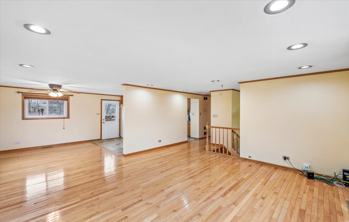 313 Springinsguth Road Schaumburg, IL 60193 - Photo 4 of 39 a view of a big room with wooden floor and windows