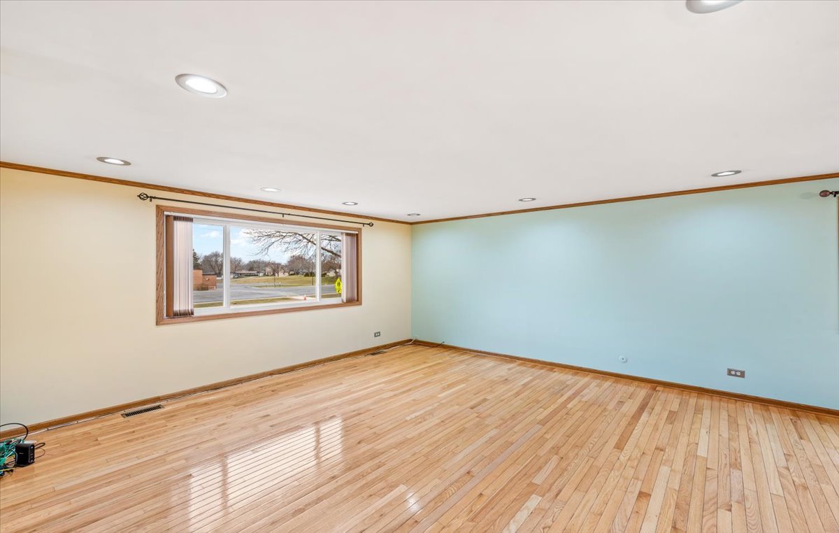 313 Springinsguth Road Schaumburg, IL 60193 - Photo 5 of 39 a view of an empty room with wooden floor and a window
