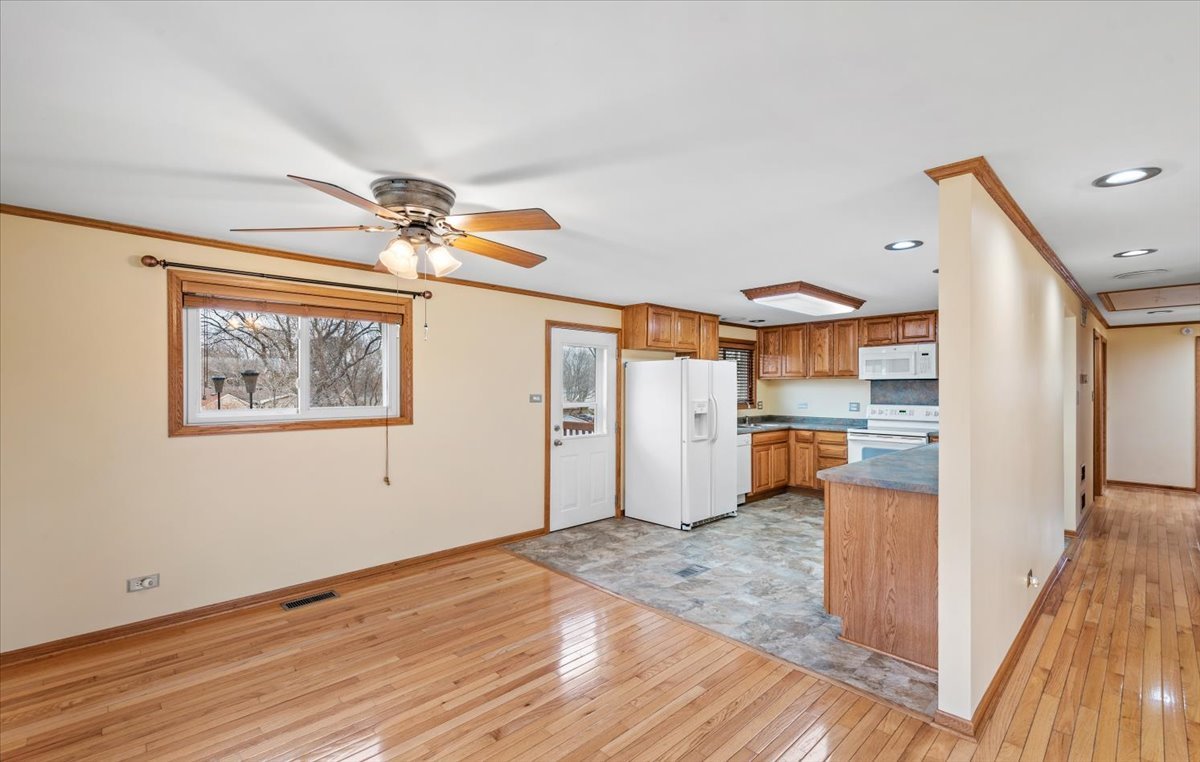313 Springinsguth Road Schaumburg, IL 60193 - Photo 7 of 39 a view of a room with wooden floor and a ceiling fan