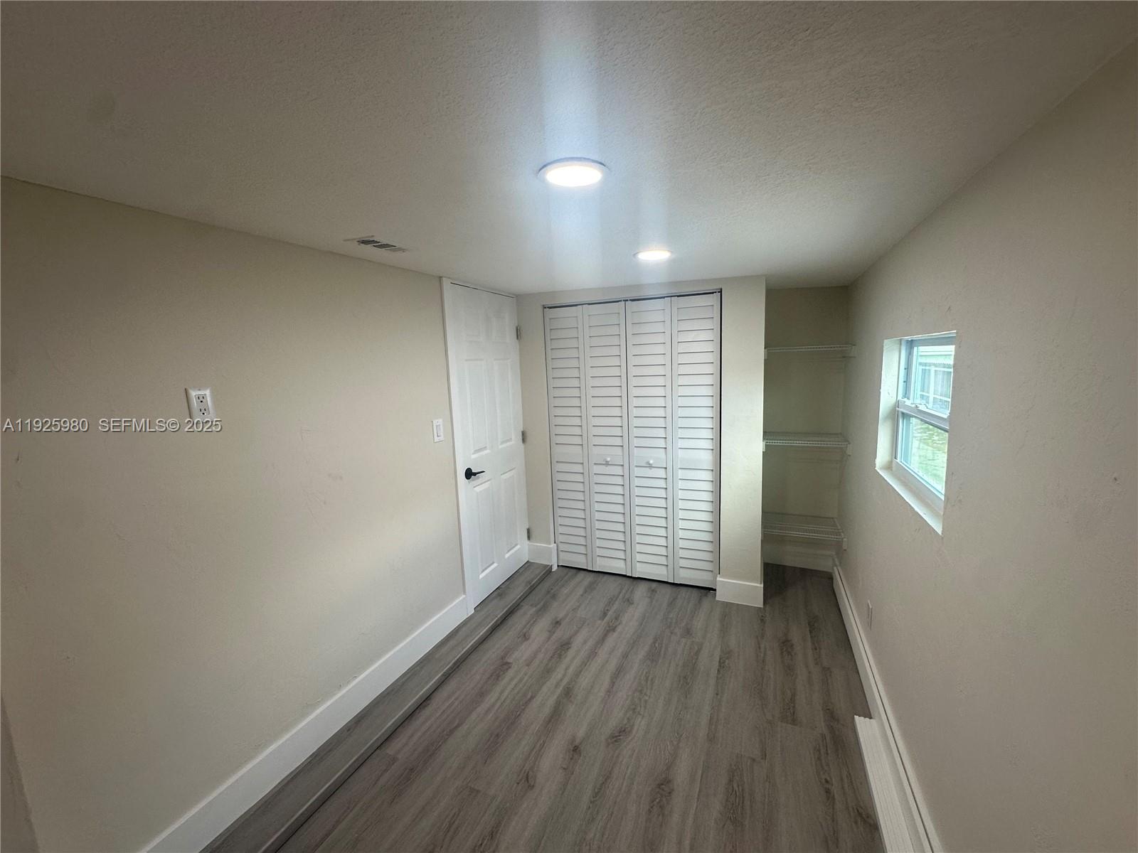 659 East 19th Street, Unit 659 Hialeah, FL 33013 - Photo 15 of 26 an empty room with wooden floor and windows