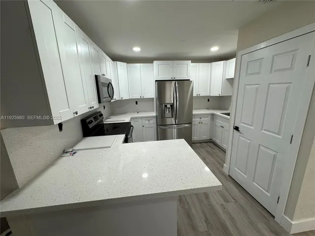 a large kitchen with a refrigerator a sink and dishwasher