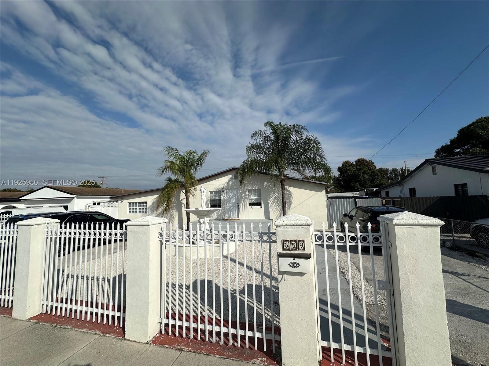 659 East 19th Street, Unit 659 Hialeah, FL 33013 - Photo 7 of 26 a view of a white house with iron fence