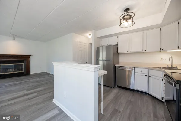 a kitchen with cabinets appliances and a wooden floor