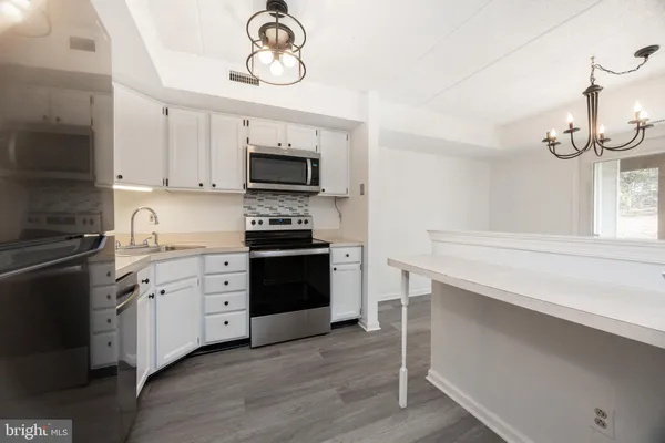 a kitchen with a stove cabinets and a wooden floor