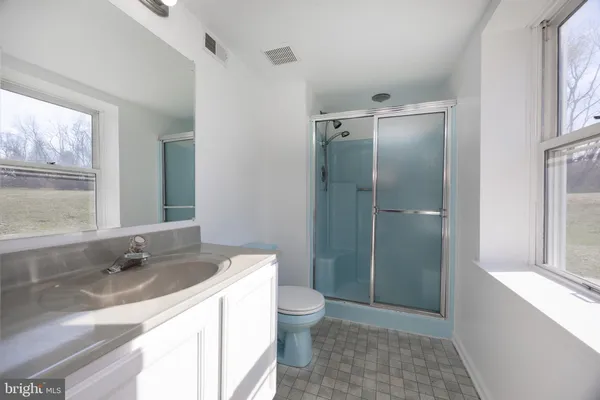 a bathroom with a granite countertop sink toilet and shower