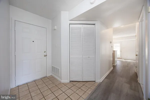 a view of a hallway with wooden floor and closet