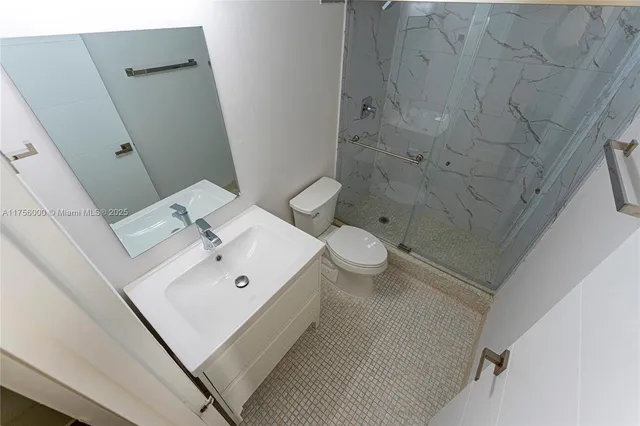 a white toilet sitting next to a bathroom sink