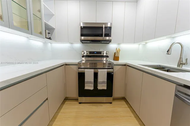a kitchen with stainless steel appliances a stove a microwave and sink