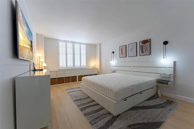 a bedroom with a bed and a dresser with mirror