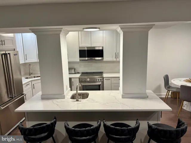 a kitchen with a sink and chairs