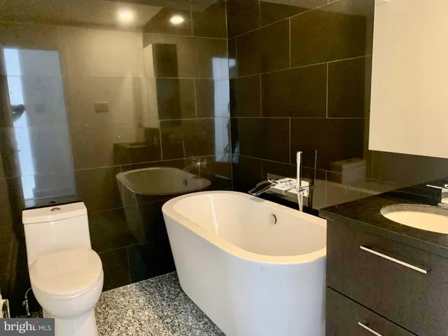 a bathroom with a sink a toilet a mirror and shower