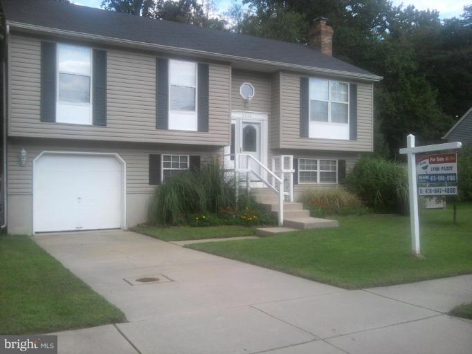 8030 Pine Ridge Road Pasadena, MD 21122 - Photo 1 of 8 a front view of a house with a yard and trees