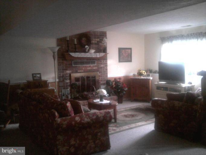 8030 Pine Ridge Road Pasadena, MD 21122 - Photo 6 of 8 a living room with furniture and a fireplace