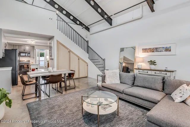 a living room with furniture a rug and a table