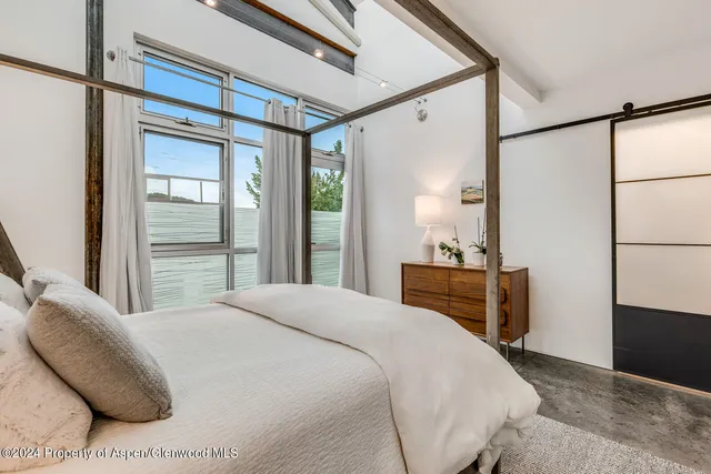 a bedroom with a bed and a dresser with mirror