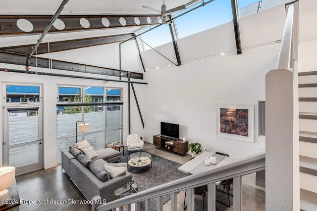 a view of a workspace with furniture and a table