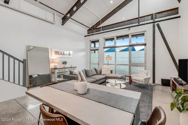 a view of a dining room with furniture a chandelier and wooden floor