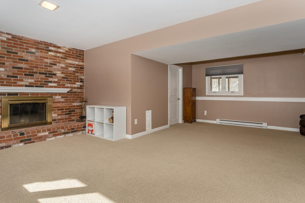 38 Clover Lane Stoughton, MA 02072 - Photo 17 of 21 a view of an empty room with a fireplace and a window