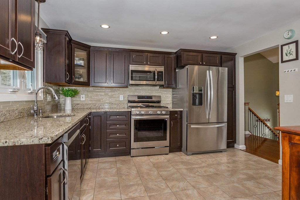 38 Clover Lane Stoughton, MA 02072 - Photo 7 of 21 a kitchen with granite countertop a refrigerator and a sink
