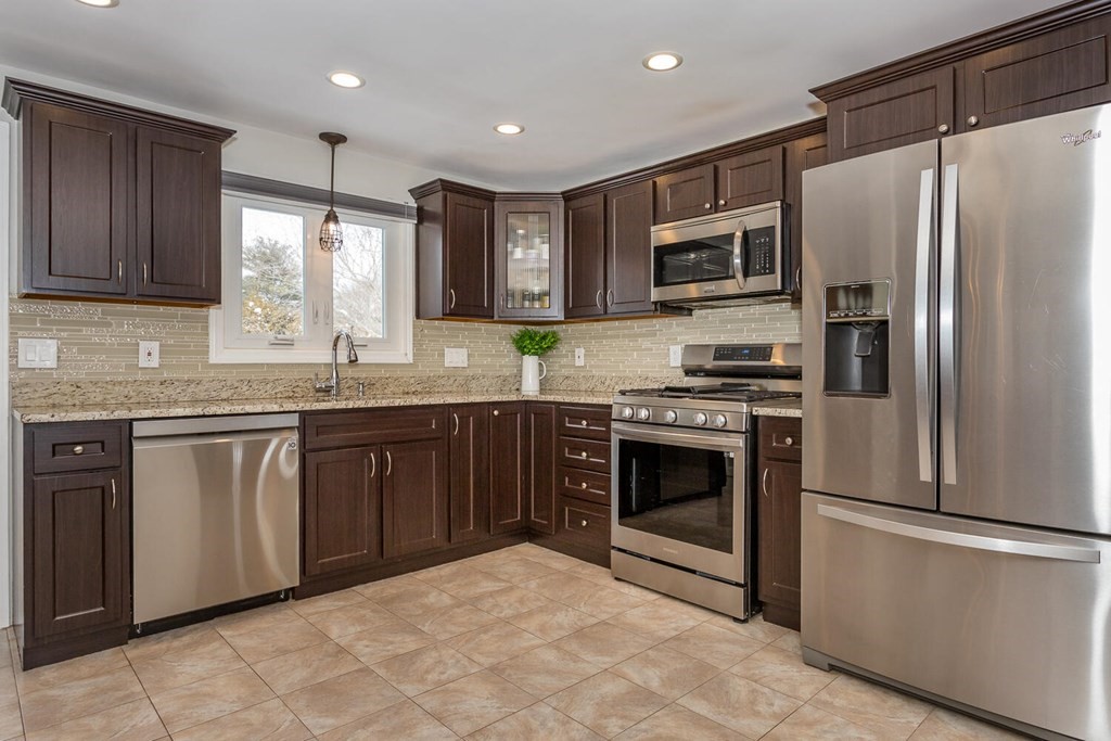 38 Clover Lane Stoughton, MA 02072 - Photo 8 of 21 a kitchen with stainless steel appliances granite countertop a refrigerator stove a sink and dishwasher
